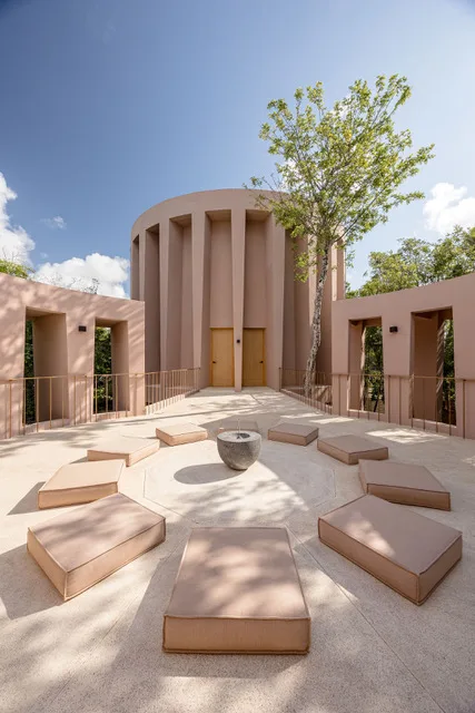 The round wellness tower from its courtyard, low cushions set in a circle on pale stone