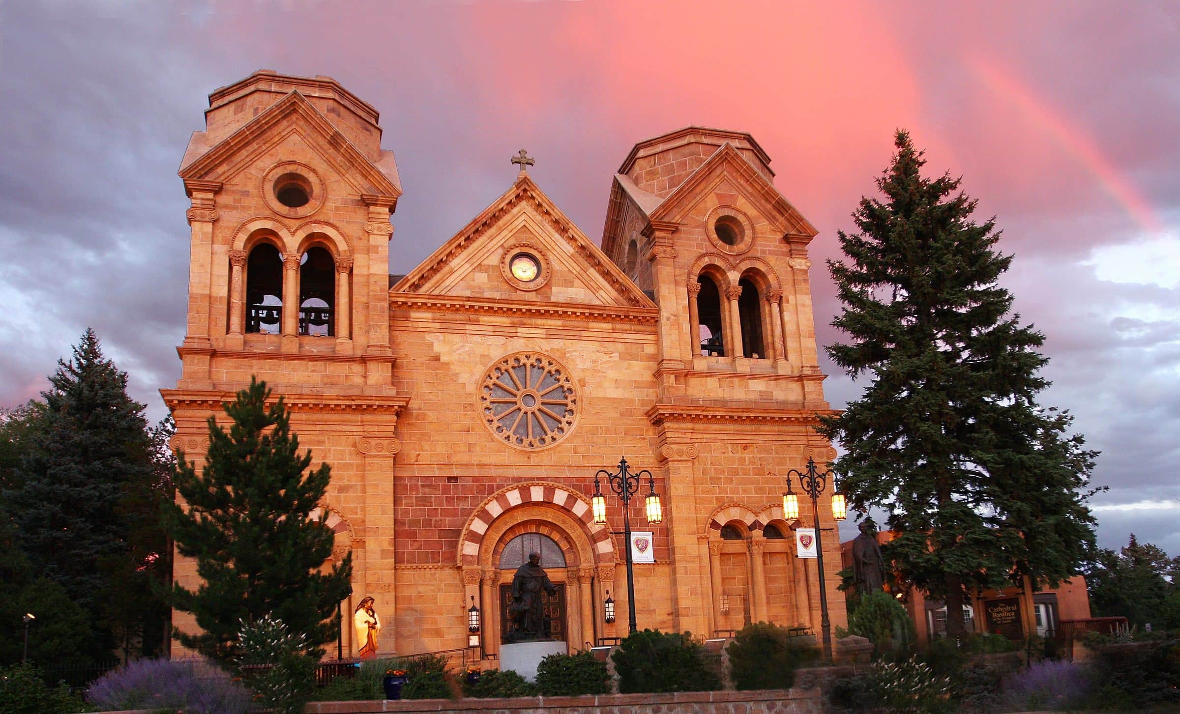 The Cathedral Basilica of St. Francis of Assisi glowing at dusk under a pink sky