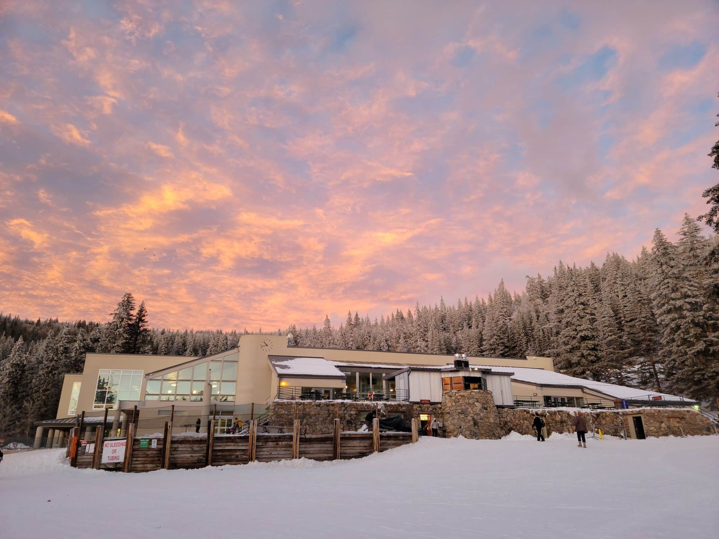 The Ski Santa Fe lodge in fresh snow under a pink sunrise sky